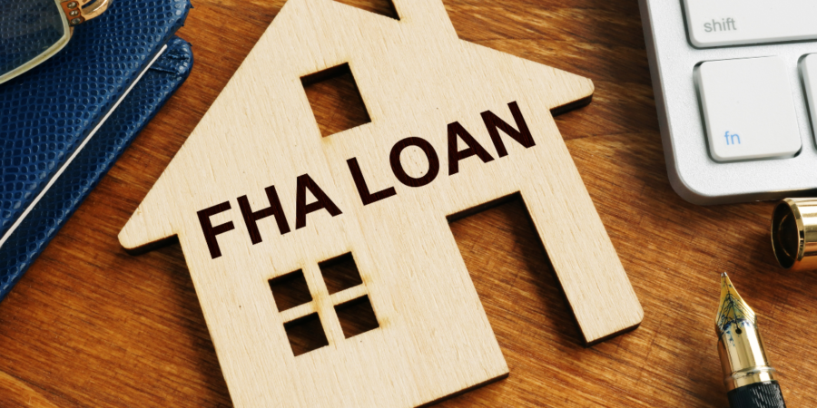 wooden house model with "FHA Loan" lettering